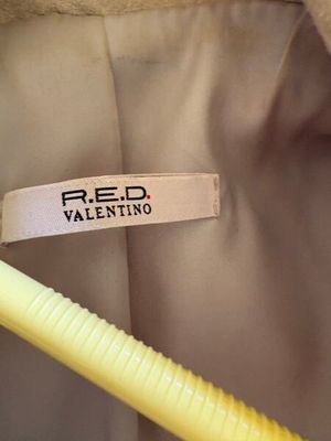 L'étiquette sur la veste porte l'inscription « Reed Valentinino » et est fixée au col d'une