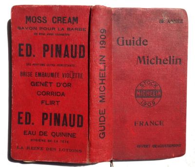 two red books sitting on top of each other on a white surface