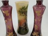 three vases are sitting on a white surface with a tree in the background