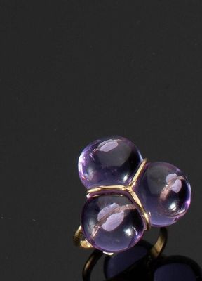 un gros plan d'une bague ornée de deux pierres violettes sur un fond noir