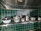 de nombreuses casseroles et poêles sur l'étagère de la cuisine