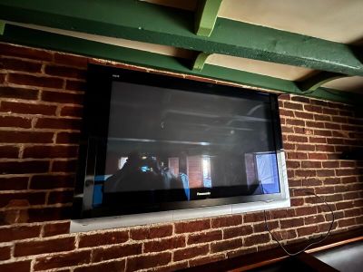 un téléviseur fixé à un mur en briques dans un salon