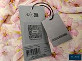 two tags on a pink flowered fabric with a barcode