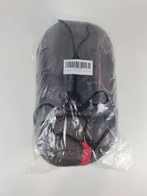 un sac noir contenant de la nourriture, emballé dans du plastique, posé sur une surface blanche