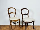 two wooden chairs sitting next to each other on top of a hard wood floor
