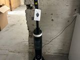 a black and white vacuum in the corner of a room