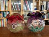 deux vases posés sur une table devant une bibliothèque