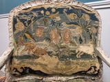 a chair that has a tapestry on the back of it