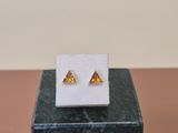 a close up of a pair of earrings sitting on top of a marble block