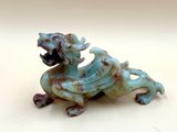 une figurine représentant un chien assis sur une table