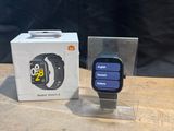 une Apple Watch posée à côté d'une boîte sur une table en bois
