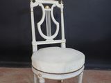 une image représentant une chaise blanche avec une harpe sur le dossier
