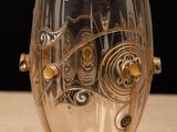 a glass cup with a design on it sitting on a table