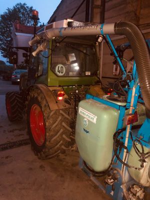 un tracteur auquel est raccordé un tuyau, dans un garage