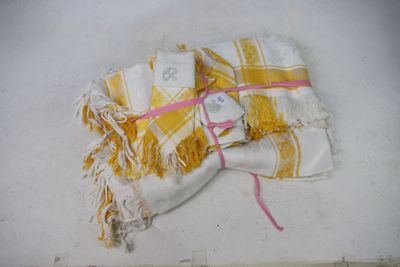 a yellow and white towel with a tag on it