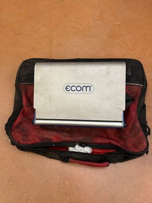 a laptop sitting on top of a bag on the floor