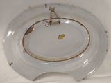 a white plate with a gold decoration on it