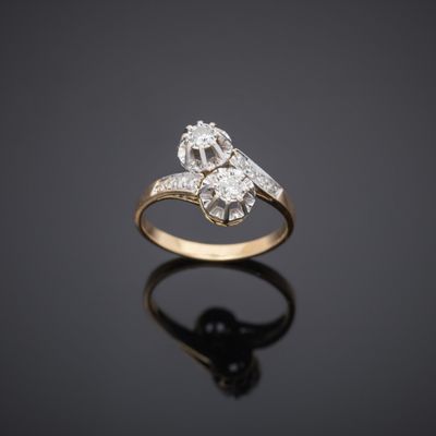 an old cut diamond ring on a reflective surface
