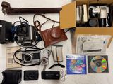 une boîte remplie d'appareils photo et d'autres objets posée sur une table