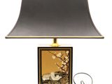 une lampe de table surmontée d'un abat-jour noir