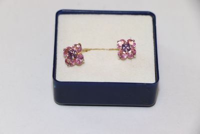 pair of pink crystal earrings in a blue box on a white surface