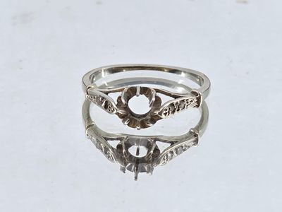a close up of a silver ring on a white surface