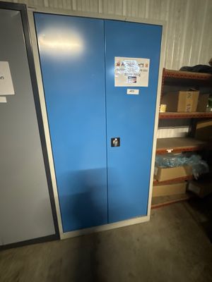une porte bleue sur laquelle est accrochée une pancarte, dans une pièce