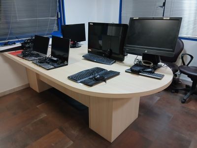 un bureau sur lequel sont posés trois ordinateurs et un clavier