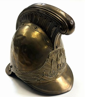 a bronze helmet on a stand on a white surface