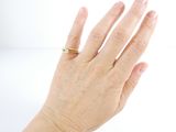 a woman ' s hand with a gold ring on it