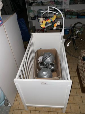un lit de bébé avec un bébé dedans, au milieu d'une pièce