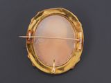 a close up of a gold plated broochle on a black surface