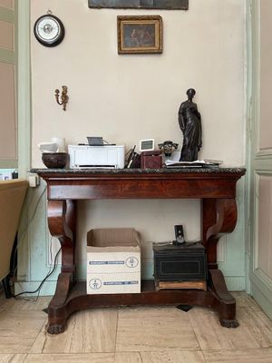 une petite table sur laquelle se trouve une horloge, dans une pièce