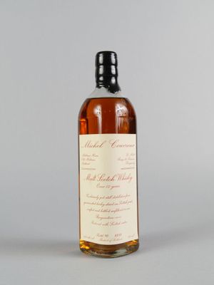 une bouteille de whisky posée sur une table blanche