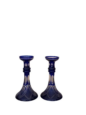 une paire de bougeoirs en verre bleu sur fond blanc