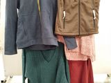 three jackets and a skirt on a rack in a store