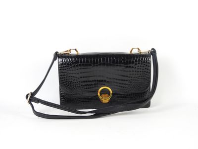 un sac à main en cuir de crocodile noir, muni d'un anneau doré sur la poignée
