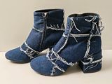 pair of blue denim ankle boots with barbed wire on them