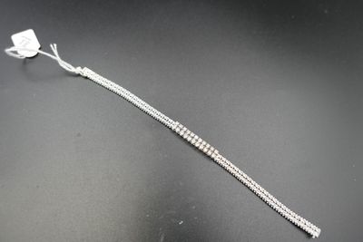 gros plan d'un bracelet en argent sur une surface noire