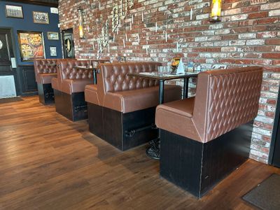 une rangée de banquettes dans un restaurant avec un mur en briques