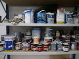 many cans of paint sitting on a shelf in a room