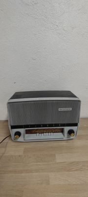 une radio posée sur un parquet, près d'un mur