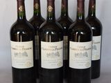 six bouteilles de vin rouge sont alignées sur une table