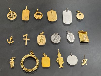 many different types of gold and silver charms on a table