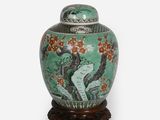 un vase vert sur lequel est représentée une femme