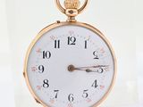 a gold pocket watch with a white face and numbers on it