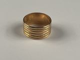 gros plan d'une bague en or sur une surface blanche
