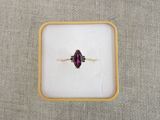 Gros plan sur une bague contenant une pierre violette