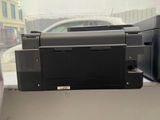a black printer sitting on top of a desk next to a window