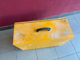 a yellow box with a black handle sitting on the floor
